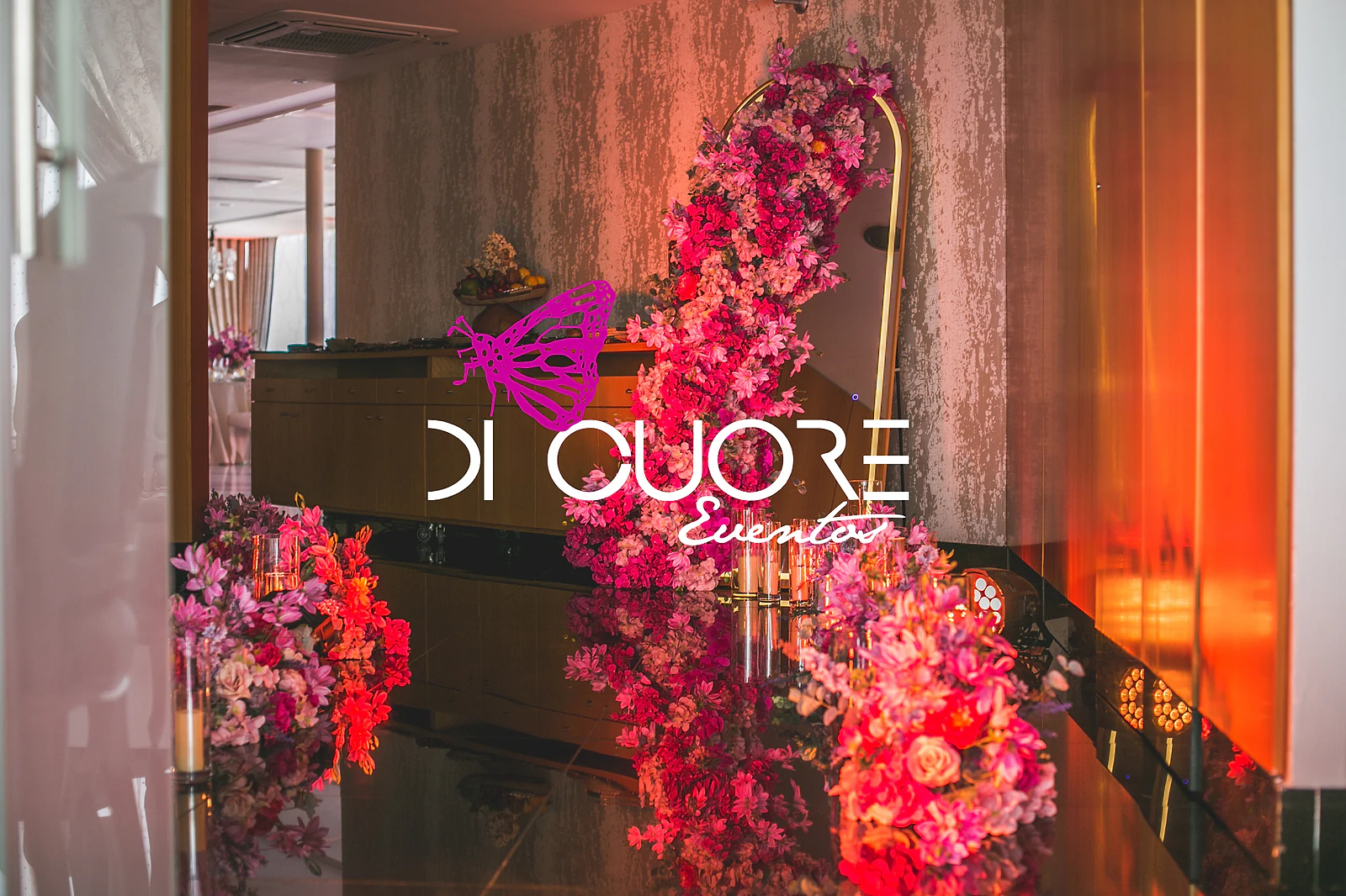 Escadaria decorada com flores vermelhas e rosa e o logótipo Di Cuore iluminado