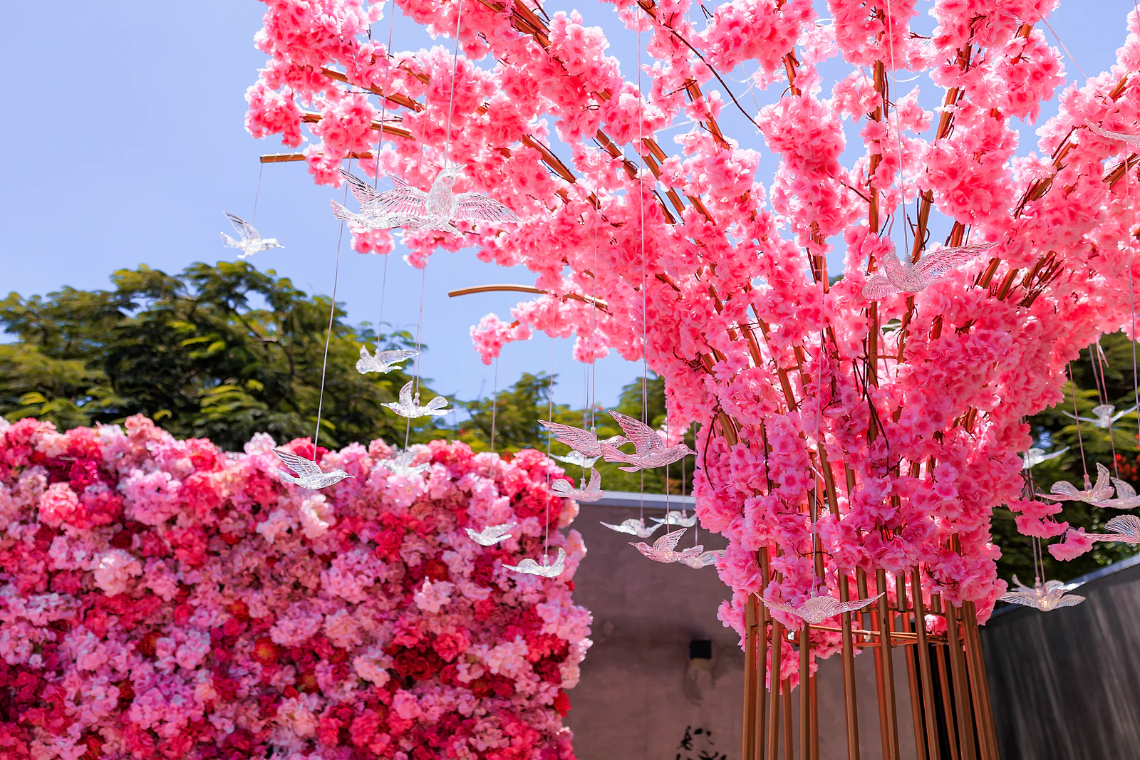Árvore de flores cor-de-rosa com borboletas suspensas contra o céu